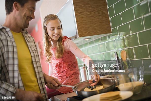 father and daughter making pancakes - breakfast fathers imagens e fotografias de stock