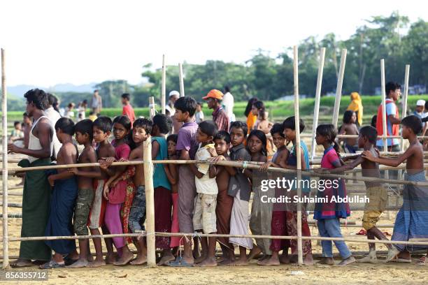Rohingya refugees queue up for food aid at the distribution point for food centre on September 30, 2017 in Teknaf, Cox's Bazar, Bangladesh. Over...