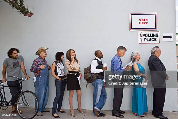 voters waiting in line at polling place - schlange bilden stock-fotos und bilder