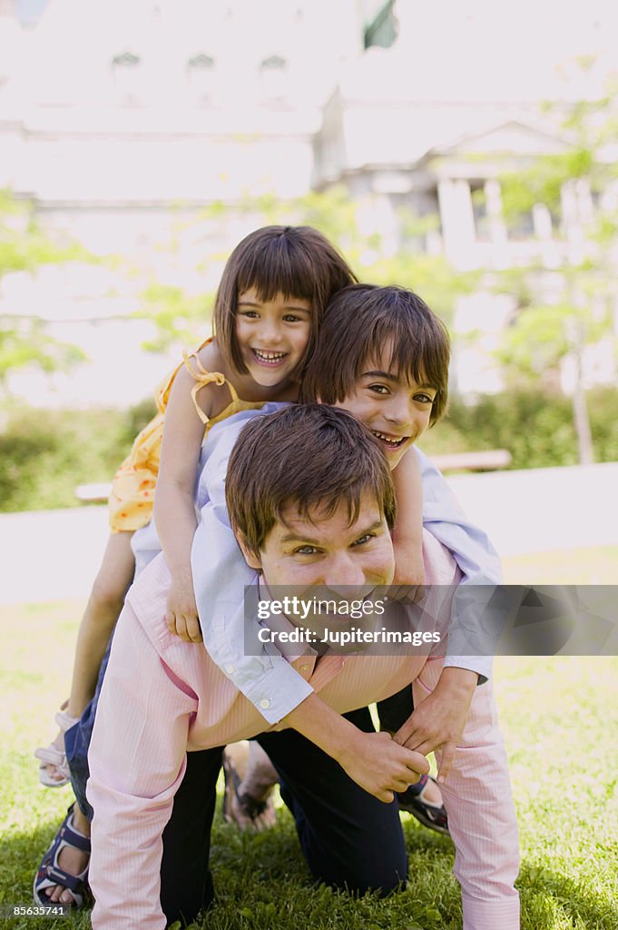 Father carrying children on back
