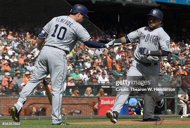 Erick Aybar of the San Diego Padres is congratulated by Hunter Renfroe after Aybar scored against the San Francisco Giants in the top of the first...