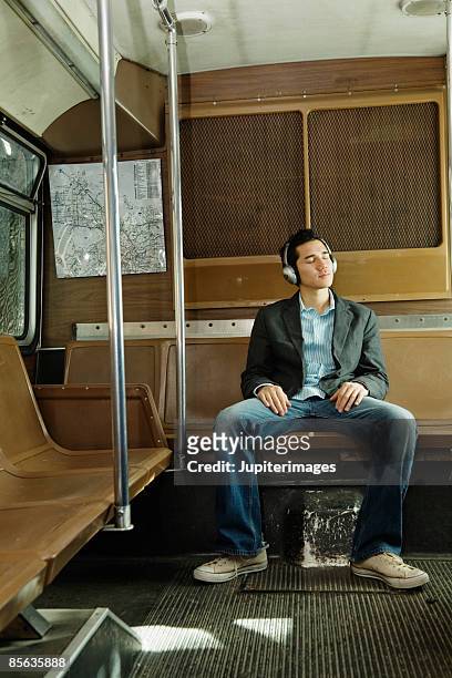 man riding bus wearing headphones - man riding bus fotografías e imágenes de stock