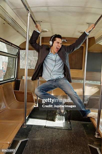 jubilant man leaping inside bus - man riding bus fotografías e imágenes de stock