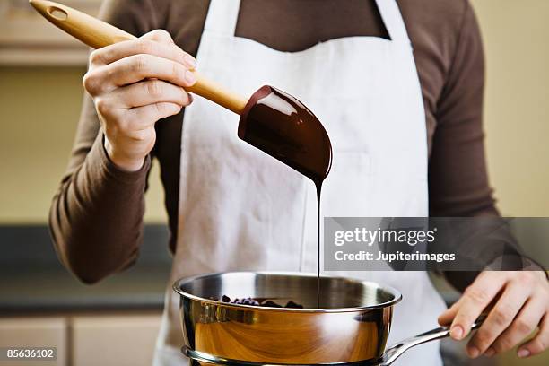 woman melting chocolate in double boiler - melting - fotografias e filmes do acervo