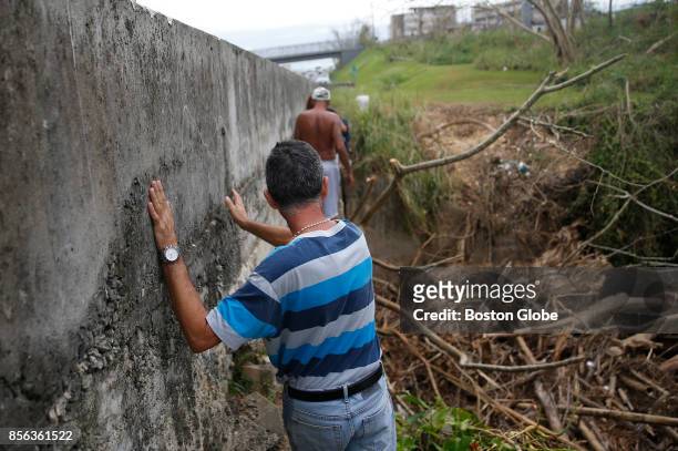 Carlos Hernandez leans against a cement barrier along the side of the highway after doing his laundry in a small river below. Hernandez lost his roof...
