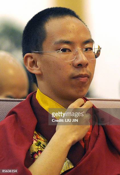 The Panchen Lama Gyaincain Norbu adjusts his clothing at a symposium marking 50th anniversary on the liberation of Tibetan slaves at the Great Hall...
