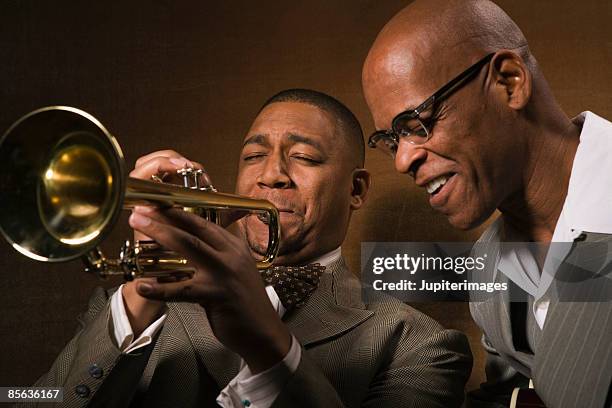 teacher listening to student playing trumpet - jazz smilling stock pictures, royalty-free photos & images