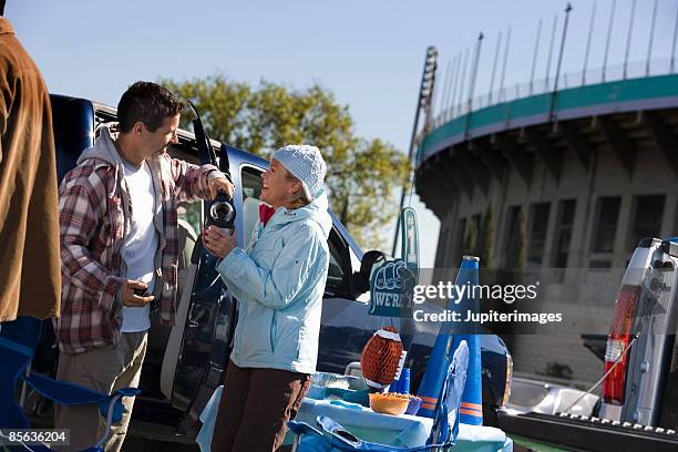 man pouring beverage at tailgate party - tailgate party stock pictures, royalty-free photos & images