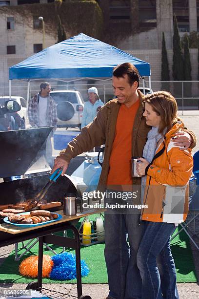 couple grilling at tailgate party - tailgating drinking stock pictures, royalty-free photos & images