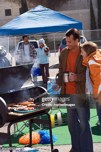 man grilling at tailgate party - football tailgate tent stock pictures, royalty-free photos & images
