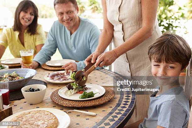 grandmother serving salad to family - angry parent mealtime stock pictures, royalty-free photos & images