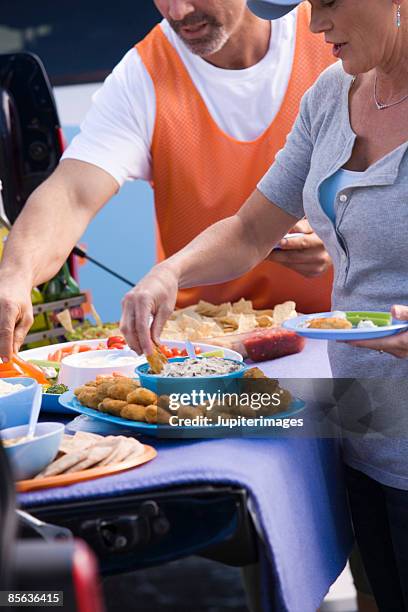 friends with finger food at tailgate party - crudité foto e immagini stock