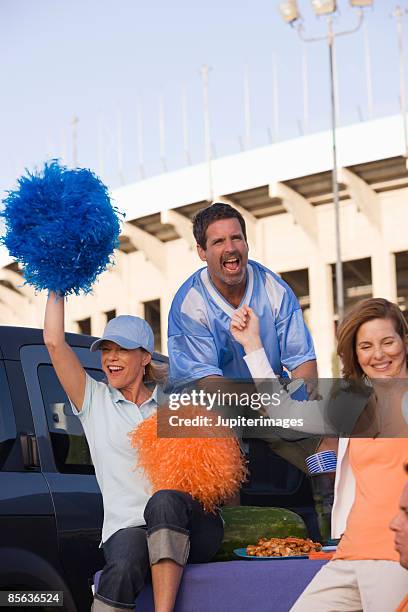 cheering friends at tailgate party - white pom pom stock pictures, royalty-free photos & images