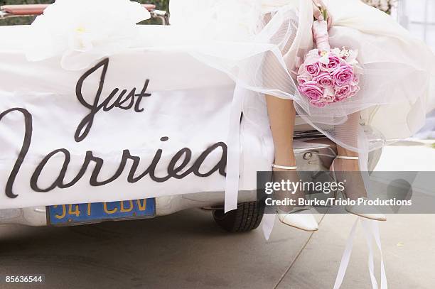 legs of bride on car with just married sign - just married sign stock pictures, royalty-free photos & images