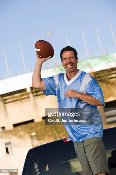 smiling man with football - man wearing sports jersey stock pictures, royalty-free photos & images