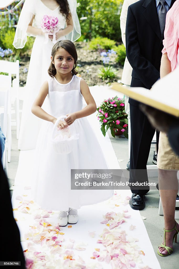 Flower girl walking down aisle at wedding