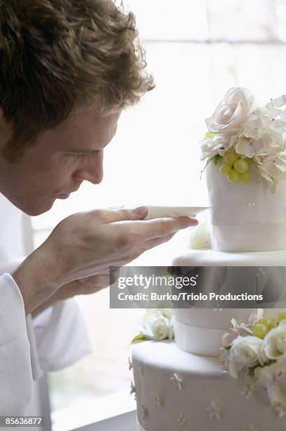 man decorating wedding cake - wedding cake baker stock pictures, royalty-free photos & images