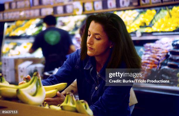 woman shopping in grocery store - banana woman stock pictures, royalty-free photos & images