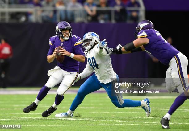 Case Keenum of the Minnesota Vikings drops back to pass the ball while pursued by defender Ezekiel Ansah of the Detroit Lions in the second half of...
