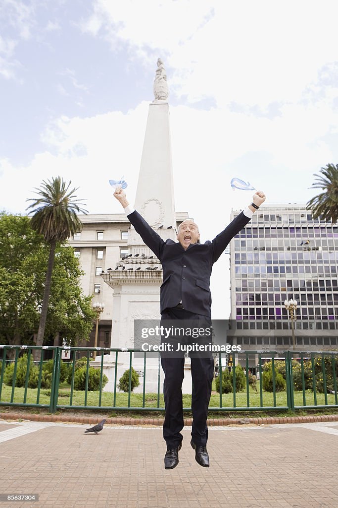 Businessman jumping with flags, Buenos Aires, Argentina