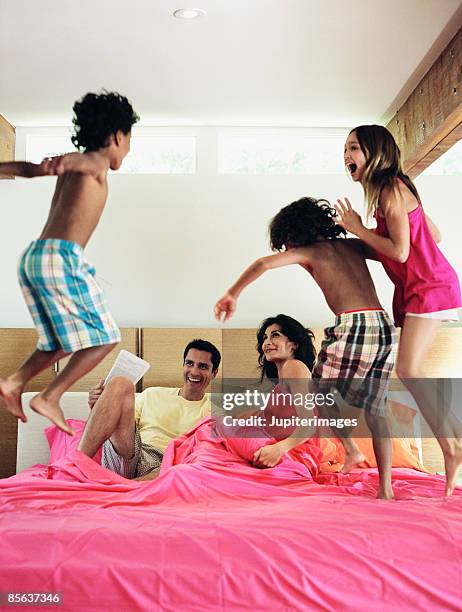 playful family on bed - nightwear stock pictures, royalty-free photos & images