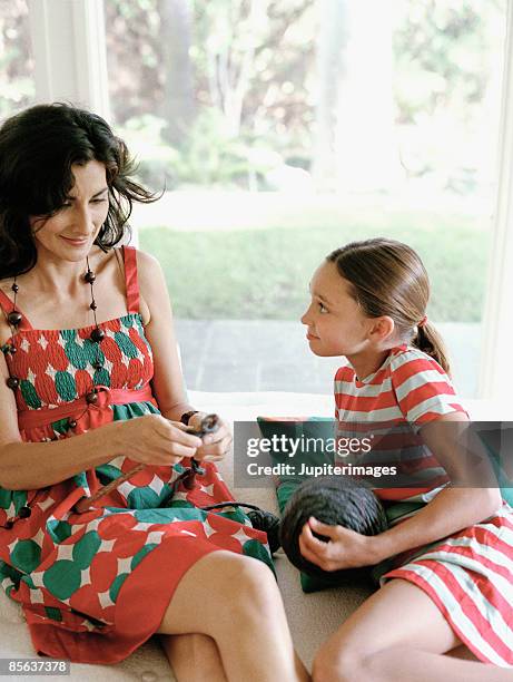 mother and daughter knitting on sofa - child knitting stock pictures, royalty-free photos & images