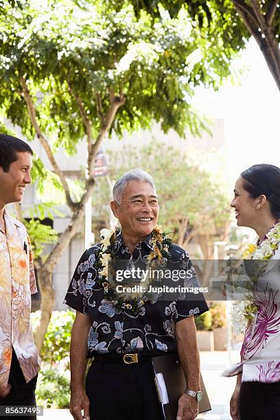 businessman with colleagues in hawaii - lei day hawaii stock-fotos und bilder