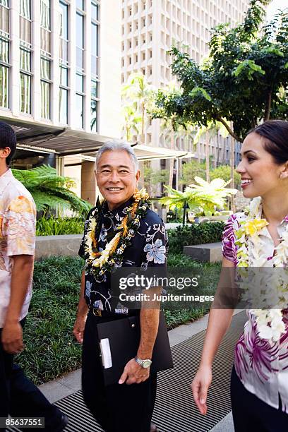 businessman walking with colleagues - hawaii hemd stock-fotos und bilder