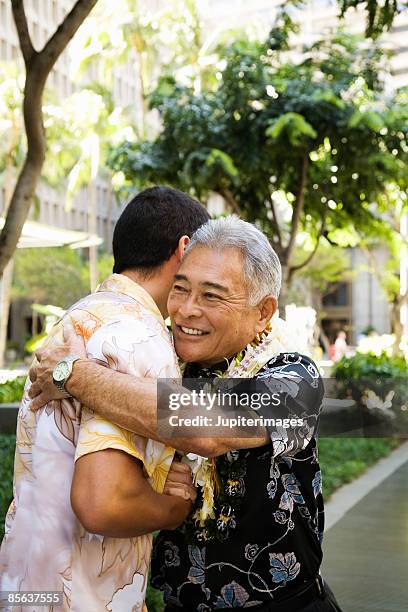 father and son embracing in hawaii - lei day hawaii stock-fotos und bilder