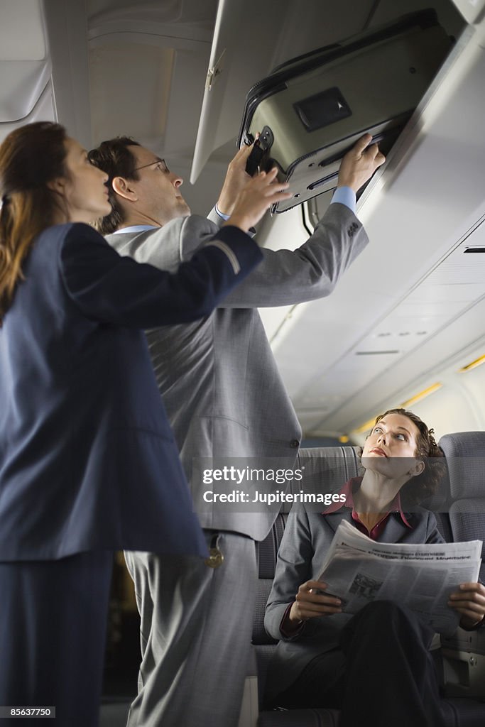 Stewardess assisting passenger with luggage