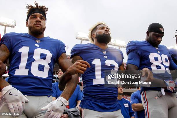 Wide receivers Roger Lewis, Jr. #18 and Odell Beckham, Jr. #13 and tight end Jerell Adams of the New York Giants lock arms during the national anthem...