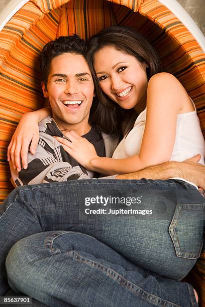 couple sitting in egg chair - egg chair stockfoto's en -beelden