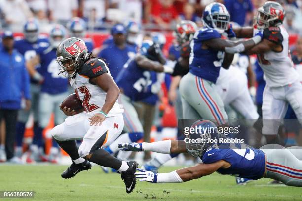 Jacquizz Rodgers of the Tampa Bay Buccaneers breaks a tackle against Olivier Vernon of the New York Giants in the first quarter of a game at Raymond...