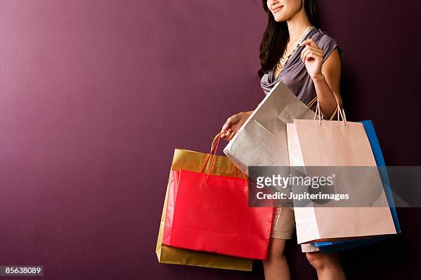 woman carrying shopping bags - einkaufstüten stock-fotos und bilder