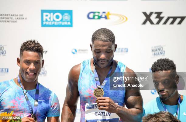 Athletes Justin Gatlin of the US, Paulo Andre de Oliveira of Brazil and Isiah Young of the US pose on the podium after the men's 100m final of the...