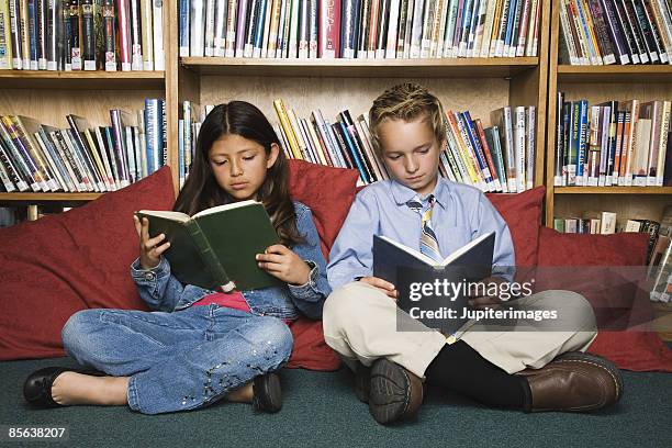 children in library reading - school tie stock-fotos und bilder