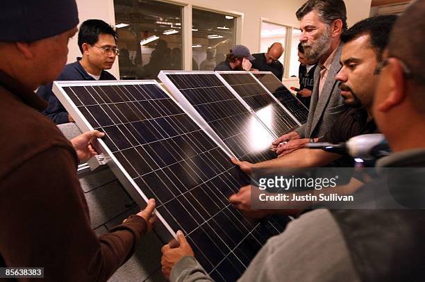 Students move photovoltaic panels during a solar panel installation course at City College of San Francisco March 26, 2009 in San Francisco,...