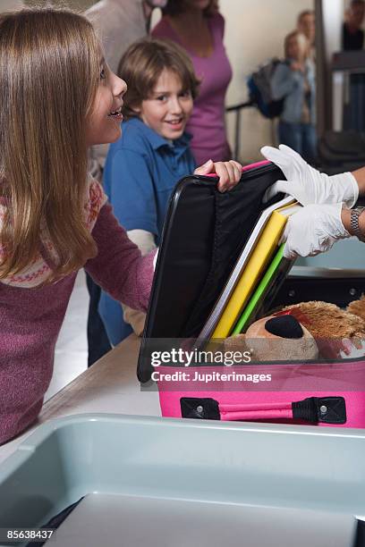airport security officer inspecting pre-teens luggage - posto de controlo de segurança imagens e fotografias de stock