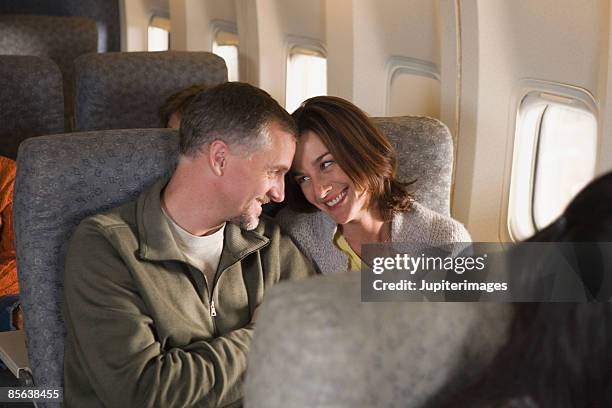 couple in intimate pose on airplane - couple airplane stock pictures, royalty-free photos & images