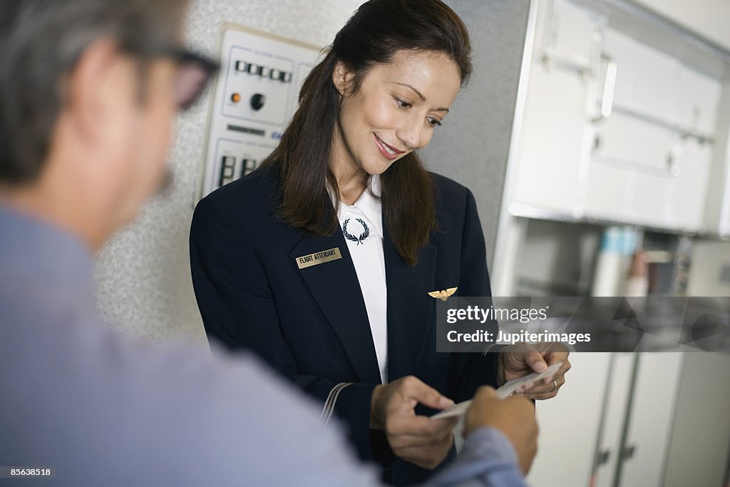 Stewardess greeting passengers on airplane