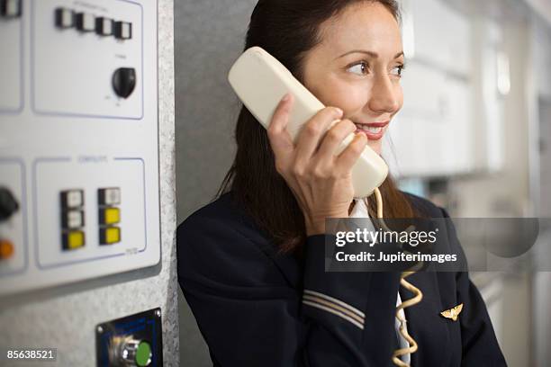 stewardess instructing passengers on airplane over the loudspeaker - air stewardess stock pictures, royalty-free photos & images