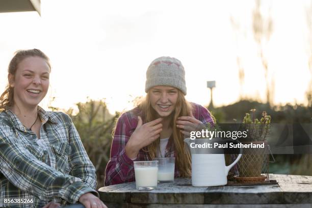 teenage farm girls at outdoors table with milk. - matamata foto e immagini stock