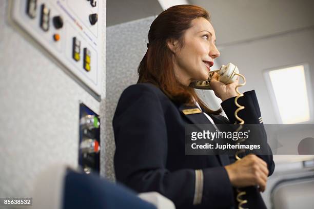 stewardess instructing passengers on airplane over the loudspeaker - crew stock pictures, royalty-free photos & images