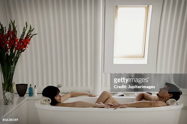 couple relaxing in bathtub together - couple bathtub photos et images de collection