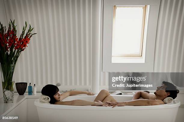 couple relaxing in bathtub together - bad relationship stockfoto's en -beelden