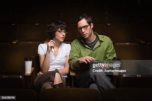 couple sitting in movie theater,25-30 years,30-35 years,adult,audition,auditorium,beverage,bohemian,brunette,casting,casting call,casting director,casual attire,caucasian,cinema,clipboard,contemplate,conversation  - clipboard and glasses stock pictures, royalty-free photos & images