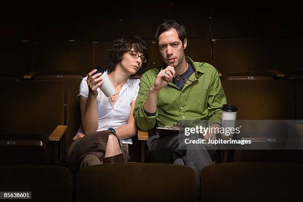 man and woman sitting in theater conducting casting call,25-30 years,30-35 years,adult,audition,auditorium,beverage,bohemian,brunette,casting,casting call,casting director,casual attire,caucasian,cinema,clipboard,coffee - criticus stock pictures, royalty-free photos & images