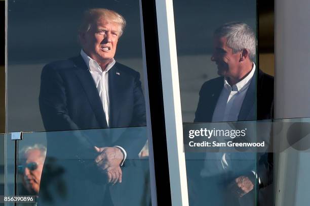 President Donald Trump looks on from the clubhouse during Sunday singles matches of the Presidents Cup at Liberty National Golf Club on October 1,...