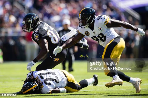 Tight end Benjamin Watson of the Baltimore Ravens is tackled by defensive back J.J. Wilcox and inside linebacker Vince Williams of the Pittsburgh...