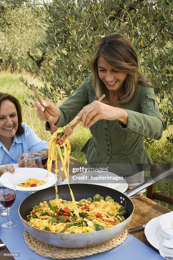 Woman serving tagliatelle pasta , Montevettolini , Italy